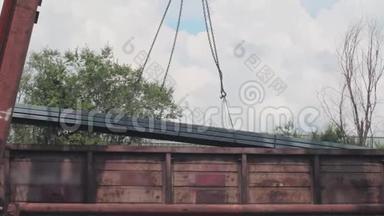 龙门吊从货车上卸下型材管道，在仓库装载金属，大型龙门吊